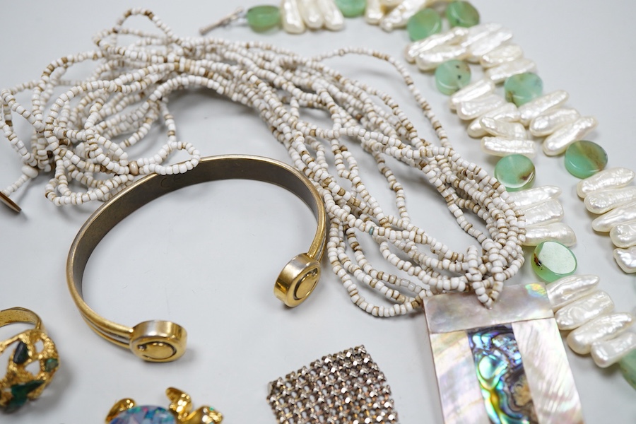 A collection of costume jewels, comprising: a floral coral and nephrite brooch; a composite opal triplet brooch designed as a turtle; a textured gilt metal ring set with hardstone fragments; a cultured pearl and chrysopr